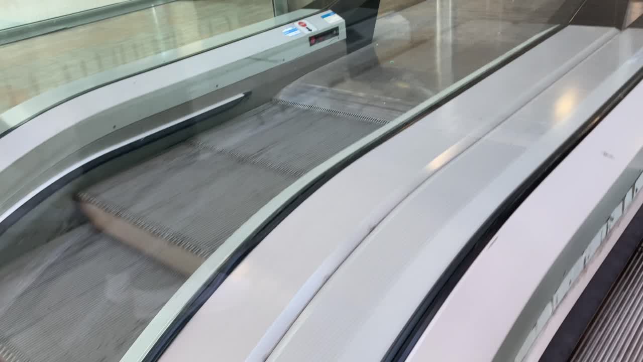 Side perspective of escalator steps in constant upward motion. Smooth mechanical movement captured in urban setting, ideal for themes of transportation, travel, or modern infrastructure