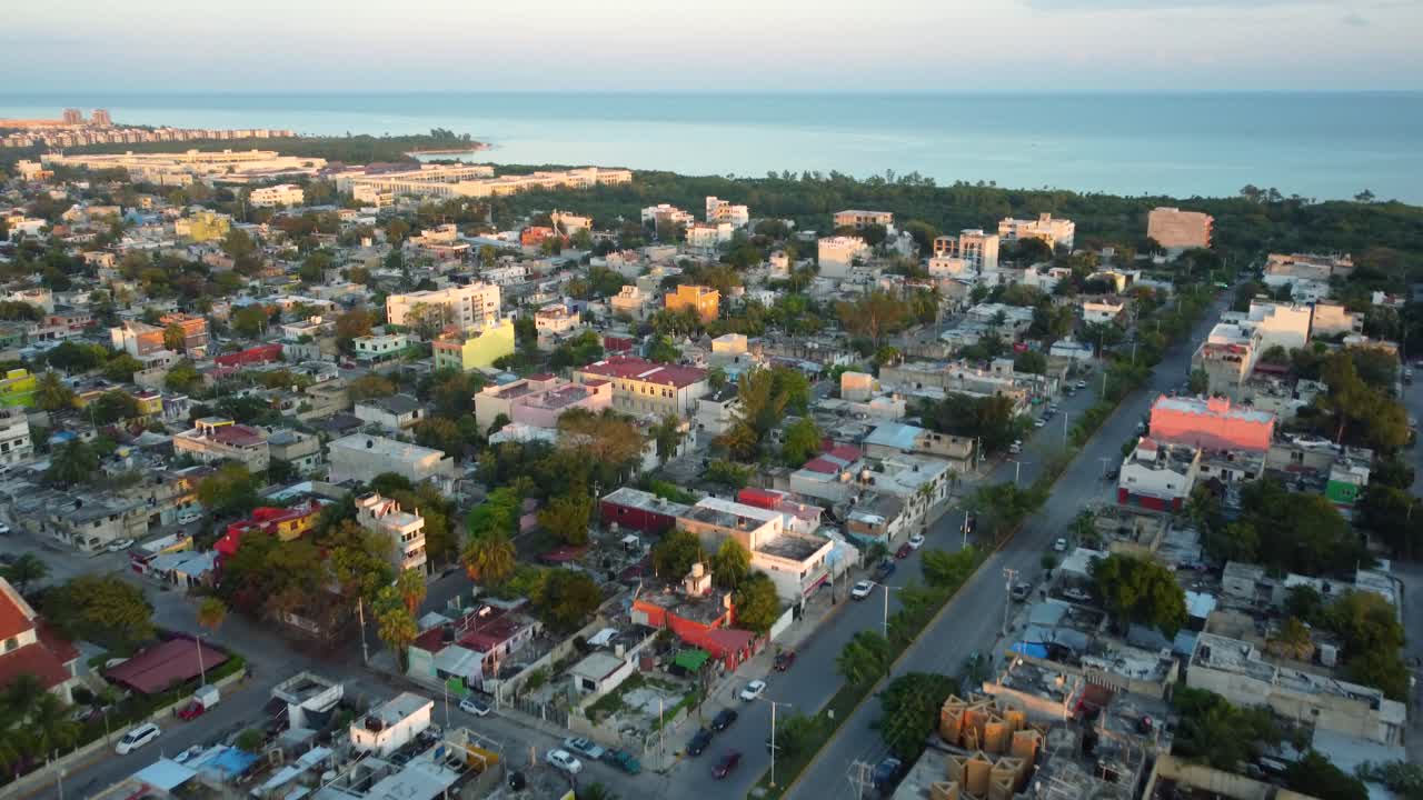A town, a beach, the sea and the horizon being embraced by a sunset in Playa del Carmen, Mexico
