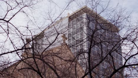 sabadell bank building offices in the background behind tree and catholic church