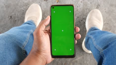person holding green screen phone