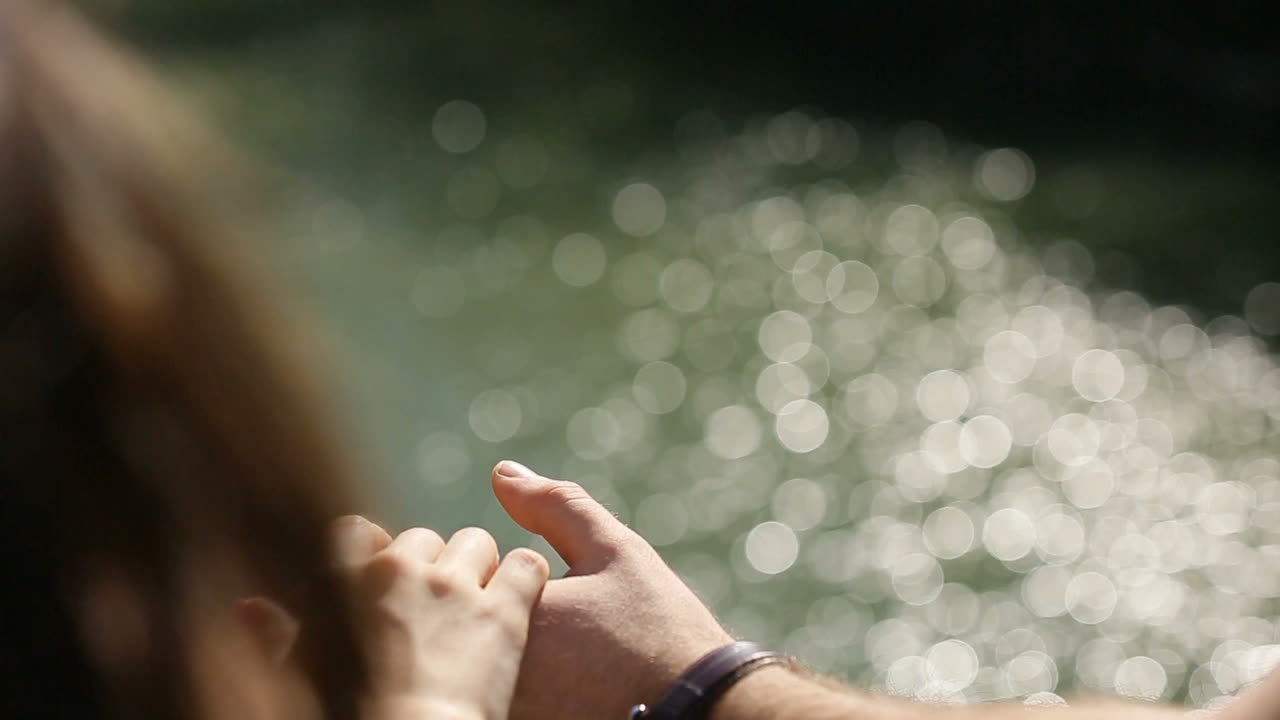 Couple holding by the hand. Back view of romantic couple holding by the hand near river