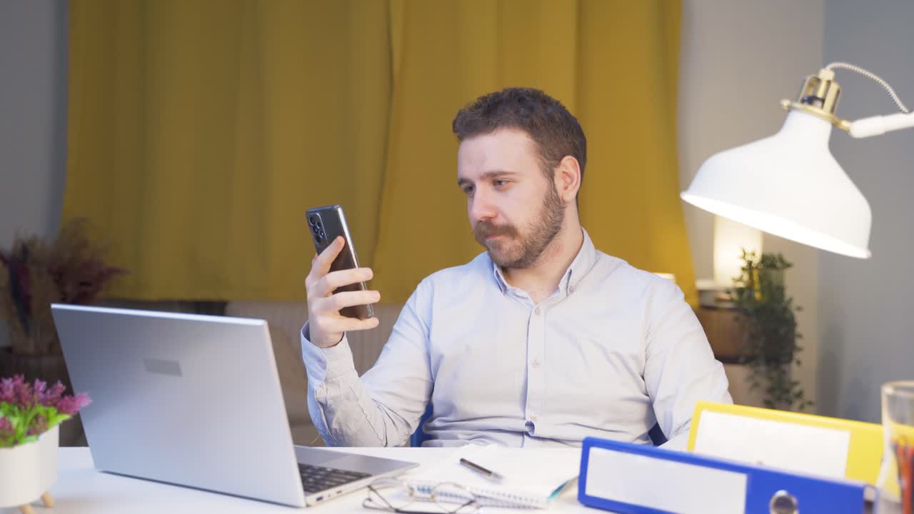 Home office worker man talking on the phone facetime happily.