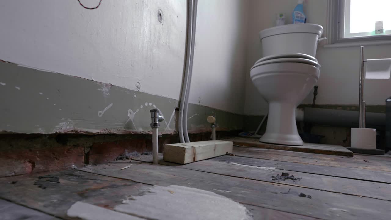 Bathroom renovation; tracking shot across stripped back room during daytime