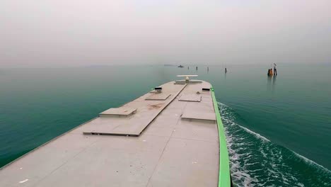 Vista-Aérea-Inusual-Del-Ferry-Que-Navega-Hacia-Las-Islas-De-La-Laguna-Veneciana,-Venecia-En-Italia