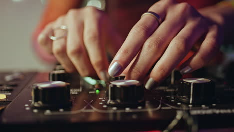 professional dj hand adjusting mixer in clubbing scene with precision closeup