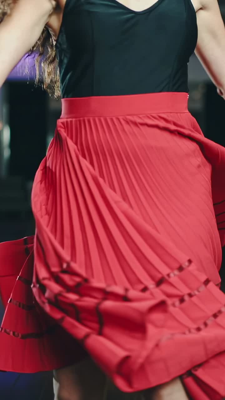 Vertical video: Spinning dancer on music cue, rotating torso and red skirt with lace-up top in club
