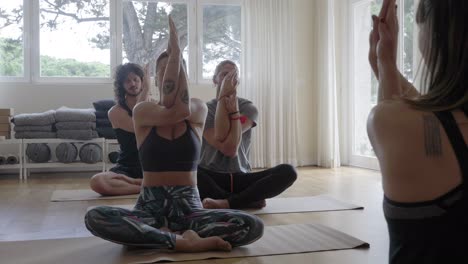 Smiling-people-practicing-yoga-indoors