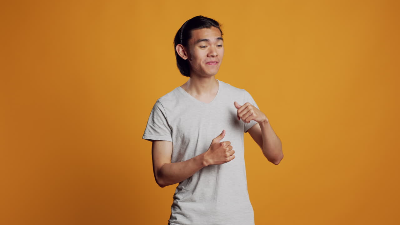 Cheerful guy showing groovy dance moves in studio