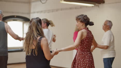 mujer madura enfocada bailando con maestra en estudio