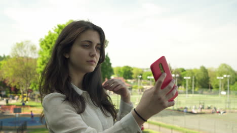 Joven-Italiana-Con-Smartphone-Tomando-Selfie-Al-Aire-Libre-En-Un-Parque-En-Londres