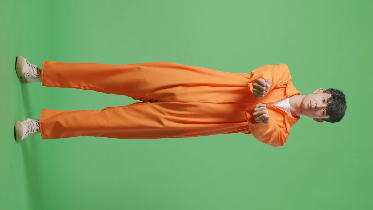 Full Body Of Asian Male Prisoner Stretching Out The Hands Surrender Himself While Standing On The Green Screen Background