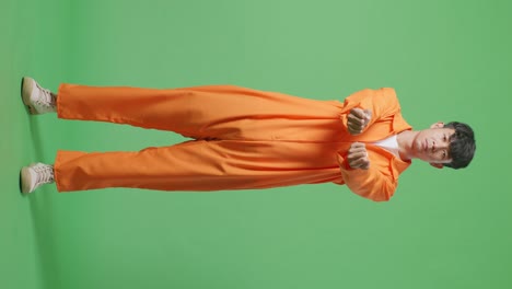 cuerpo lleno de prisionero masculino asiático estirando las manos se rinde mientras está de pie en el fondo de la pantalla verde