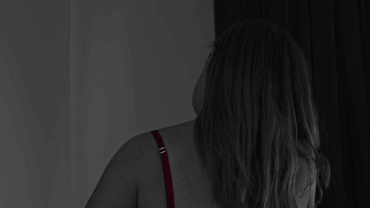 parcialmente coloreada desaturada - hermosa mujer en lencería poniéndose las correas vascas