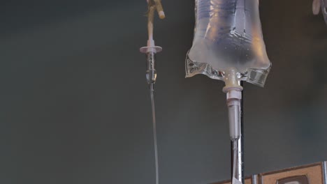 an iv bag hanging and dispensing medicine to a patient in a hospital room