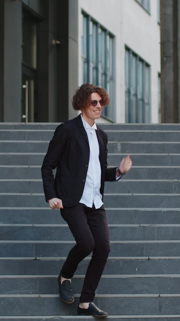 empresario emocionado celebrando en los escalones caminando después de una entrevista de trabajo promoción bailando éxito