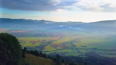 bird's eye view on sunlight covered valley, mountains and cloudy sky background