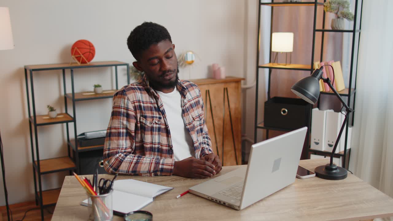 Tired man teacher using laptop computer suffering from tension migaine headache at home office