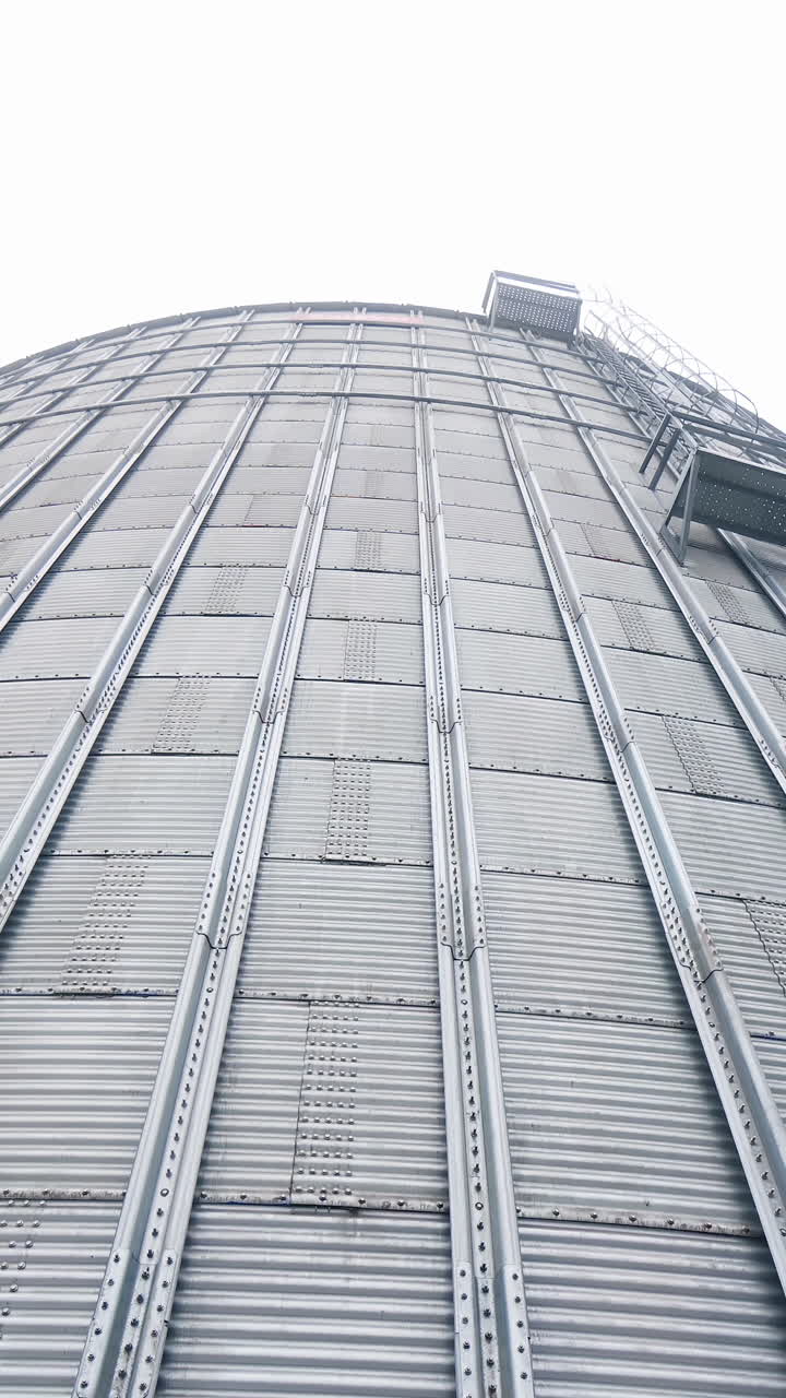 Big storage elevator construction. Steel hude agricultural storage for farming. Vertical video