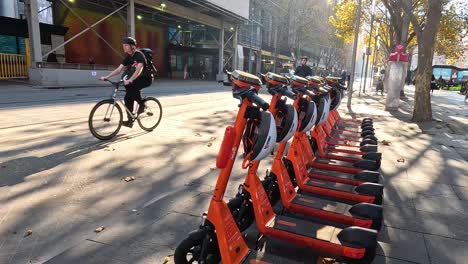 scooters lined up, cyclists passing by