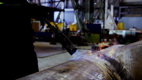 ingeniero masculino que utiliza una máquina de soplador de fuego en el taller 4k