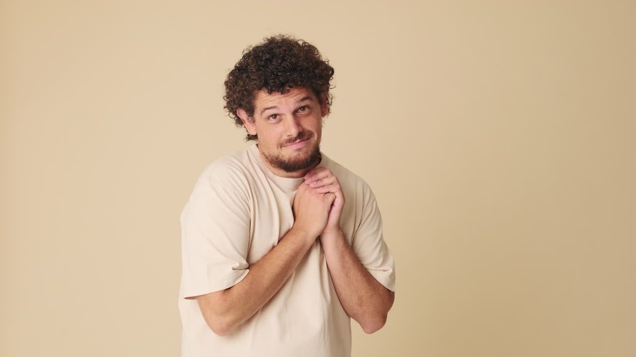 Young Man Making Pleading Gesture with Hands Together