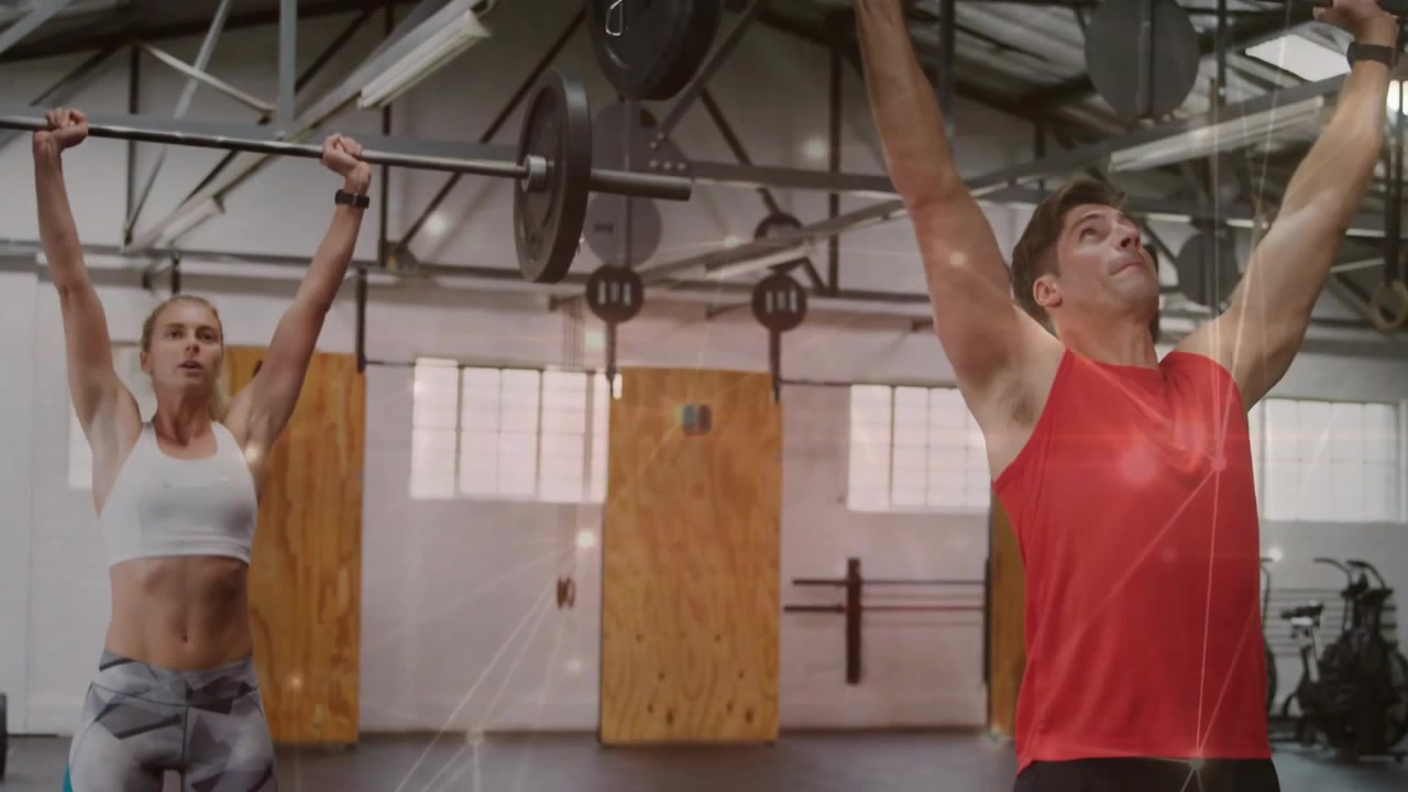 Male and female athletes hinging, performing clean to press barbell overhead in gym for fitness