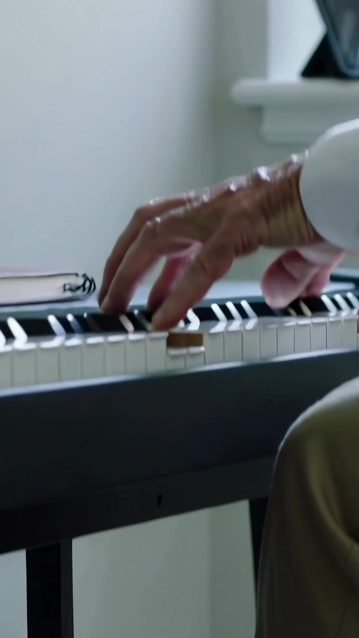 Vertical video: Playing senior player starting, pressing keys at home using pedal in white shirt