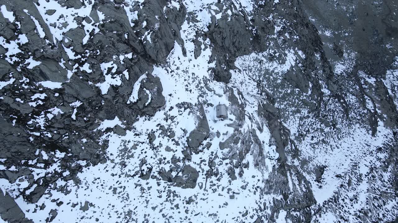 imágenes de drones de arriba hacia abajo de un refugio en montañas nevadas