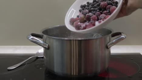 Add-the-wrozen-berries-in-boiling-water.-Cooking-compote.-Kitchen.-Slow-motion