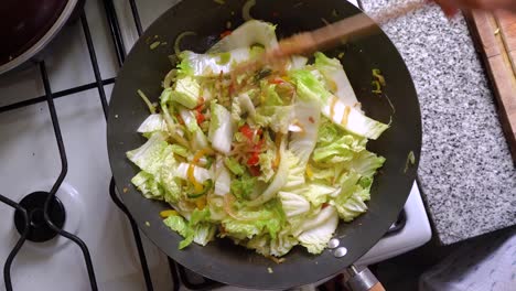 Stirring-Mixed-Vegetables-With-Napa-Cabbage-In-A-Wok-Using-Wooden-Spoon