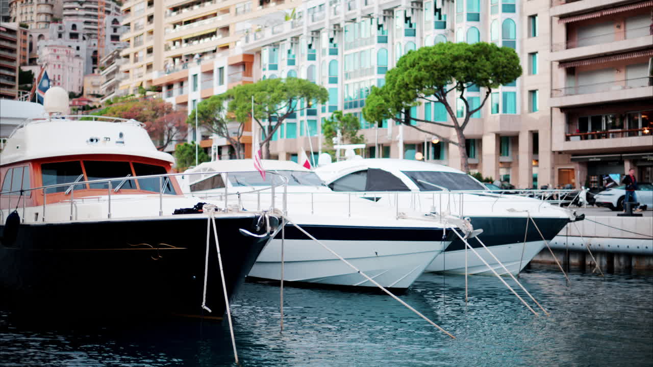 View of boats docked in the Monaco Marina with the skyline of the city on the background