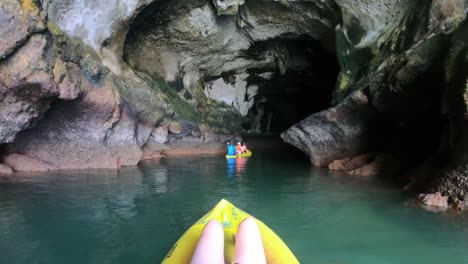 ir pro perspectiva cámara lenta de chica en kayak entrando en cueva de gira en tailandia phang nga