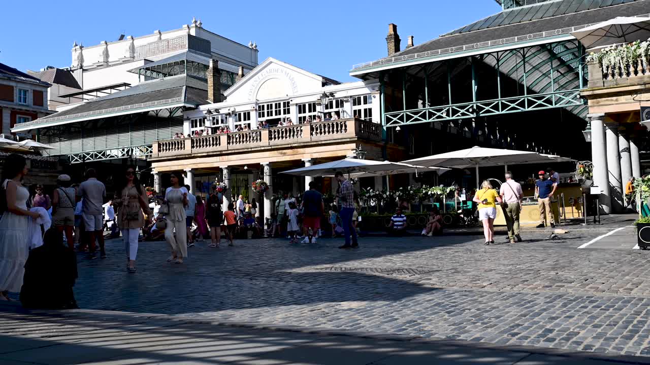 Time lapse looking  towards the Punch and Judy Rooftop Pub  and crowds of people at the Covent Garden market