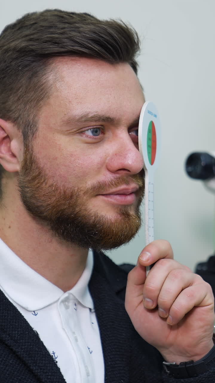 Handsome male checks vision in ophthalmological clinic. Optometrist trial frame. Healthcare concept. Vertical video