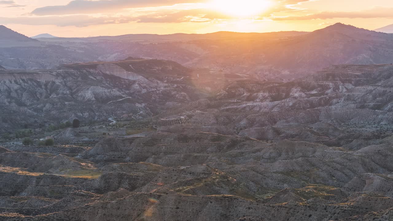 Golden sunset over dry hills and textured land in Gorafe desert