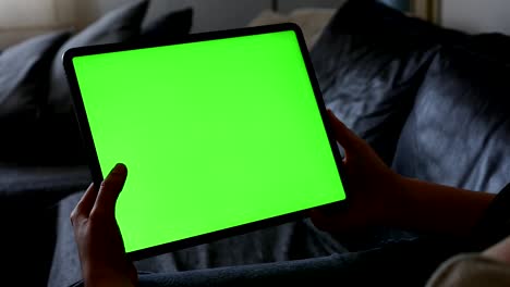 tableta de pantalla verde en las manos en casa video 4k