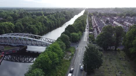 Vista-Aérea-Del-Canal-De-Barcos-De-Manchester-Puente-Giratorio-Warrington-Inglaterra-Pasando-Por-Encima-Del-Cementerio