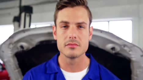 mechanic standing in repair shop with wrench