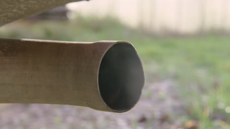 extreme close up tailpipe as engine runs, 60fps slow motion