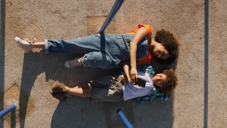 mother and son using phone at playground