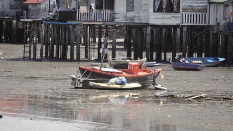 Ein-Lokales-Thailändisches-Fischerboot,-Das-Bei-Ebbe-Auf-Dem-Sand-In-Si-Raschha,-Thailand,-Gestrandet-Ist