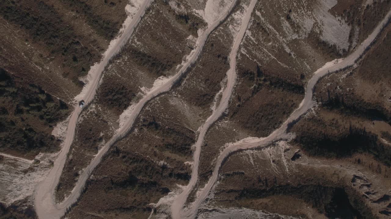 Filmato drone della ripida strada sterrata a zigzag che scende dal Passo Katu-Yaryk in una valle rocciosa nella Repubblica dell'Altai, Russia, che mostra un drammatico terreno montuoso e un percorso di viaggio