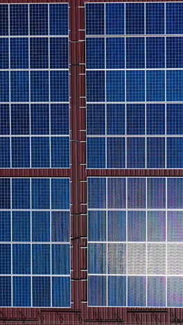 solar panels from above. aerial drone view of solar panels on the roof of building vertical video