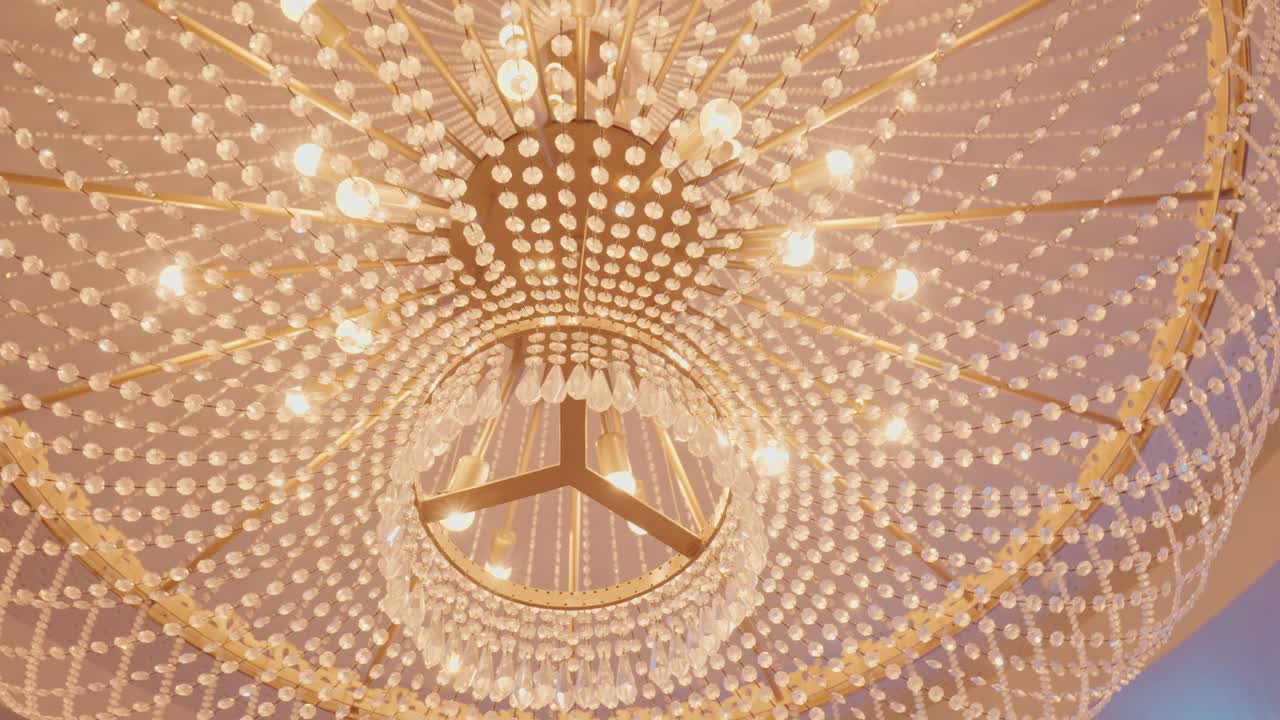 opulent golden chandelier with cascading crystals illuminated in grand ceiling design