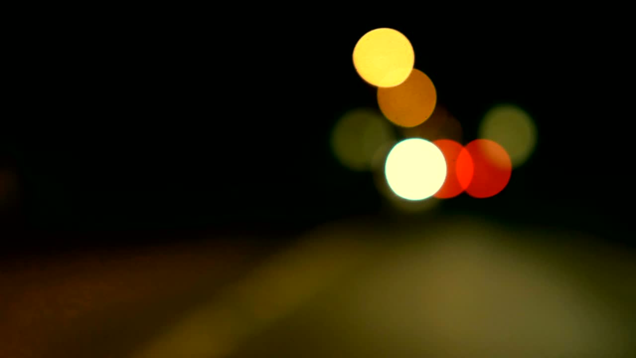 conducir un coche a través de la carretera de la noche, la autopista. luces desenfocadas calle de los ángeles resumen. ciudad fondo borroso. movimientos círculos bokeh de tráfico nocturno.