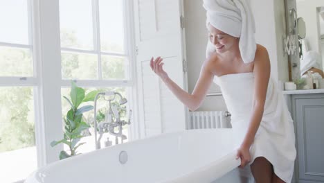 happy asian woman running bath in bathroom, in slow motion