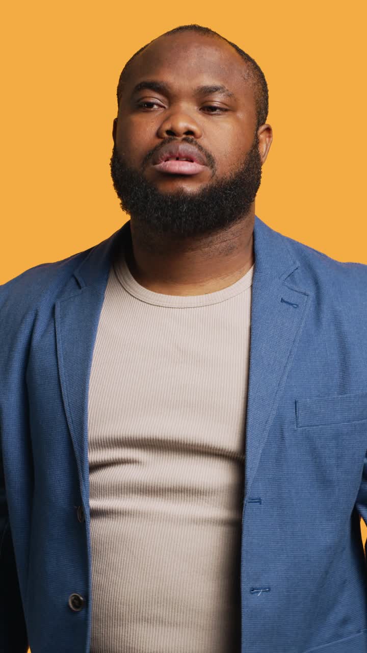 Vertical video Man shrugging shoulders, not caring, studio background