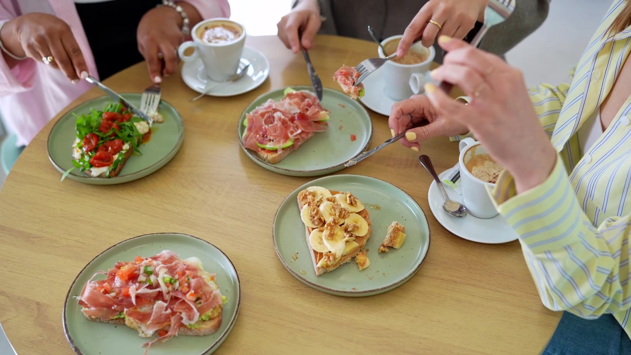 Amici che gustano toast gourmet e bevono caffè al bar