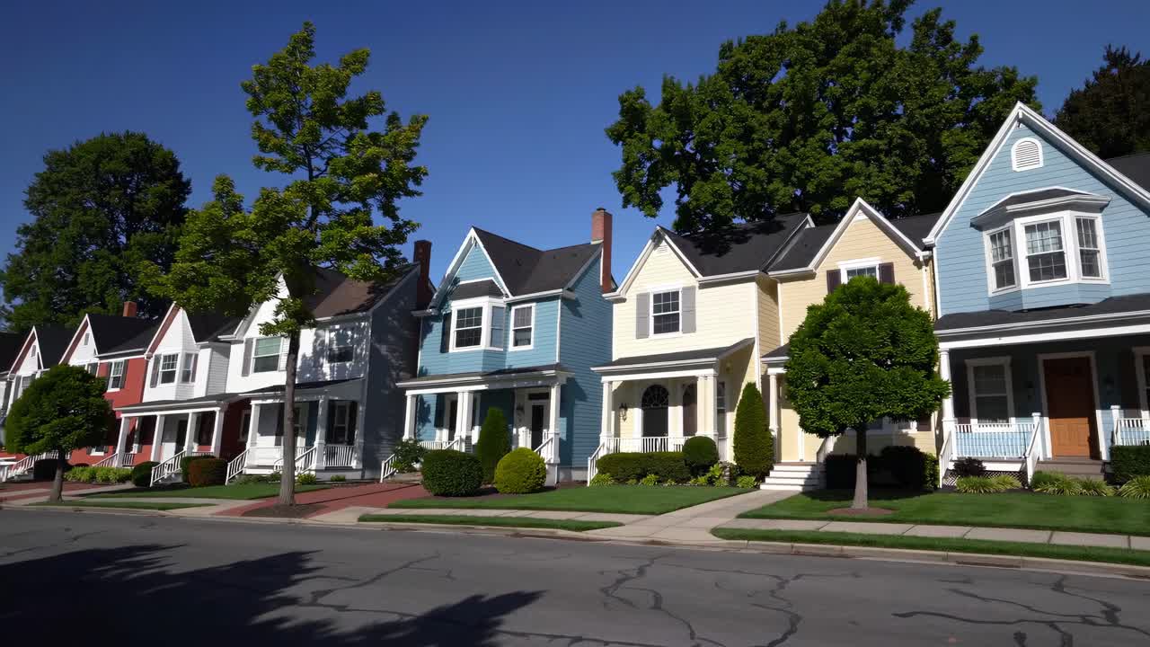 The video showcases a serene suburban street with colorful houses, lush trees, and clear skies