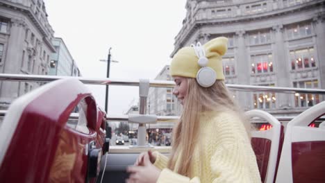 blond teenage tourist with headphones on bus